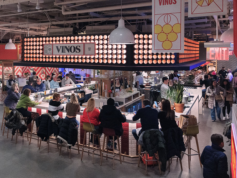 Patrons sit around an open bar counter at Vinos Wine Bar