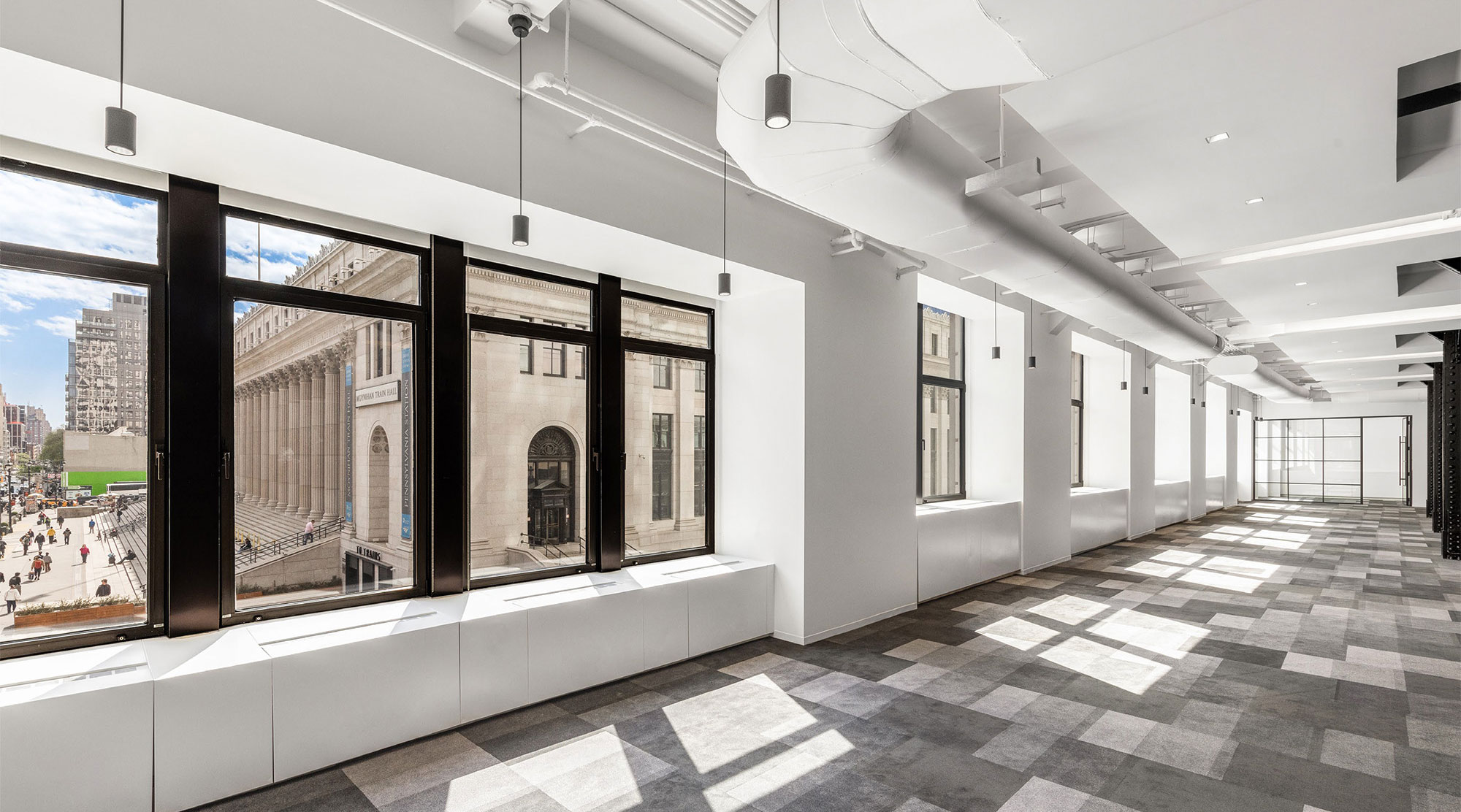 Carpeted hallway with several windows overlooking NYC